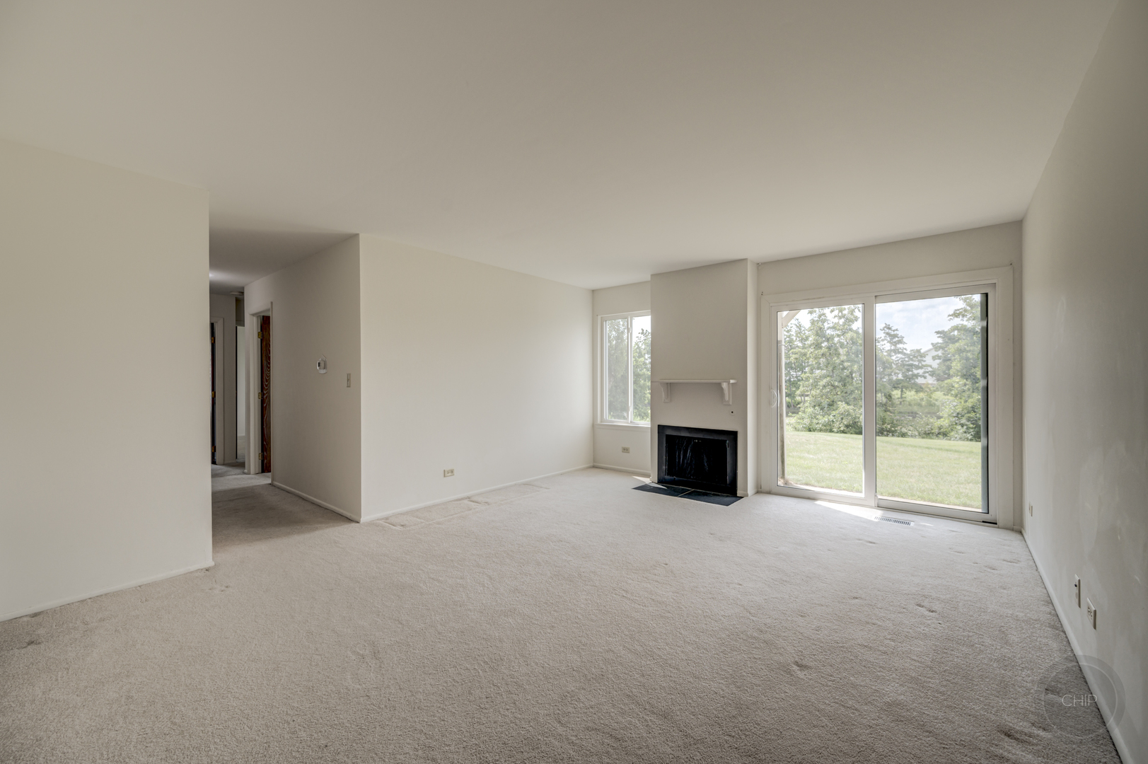 360 Springlake Lane, Unit B Aurora, IL 60504 - Photo 12 of 26 an empty room with large windows and a fireplace