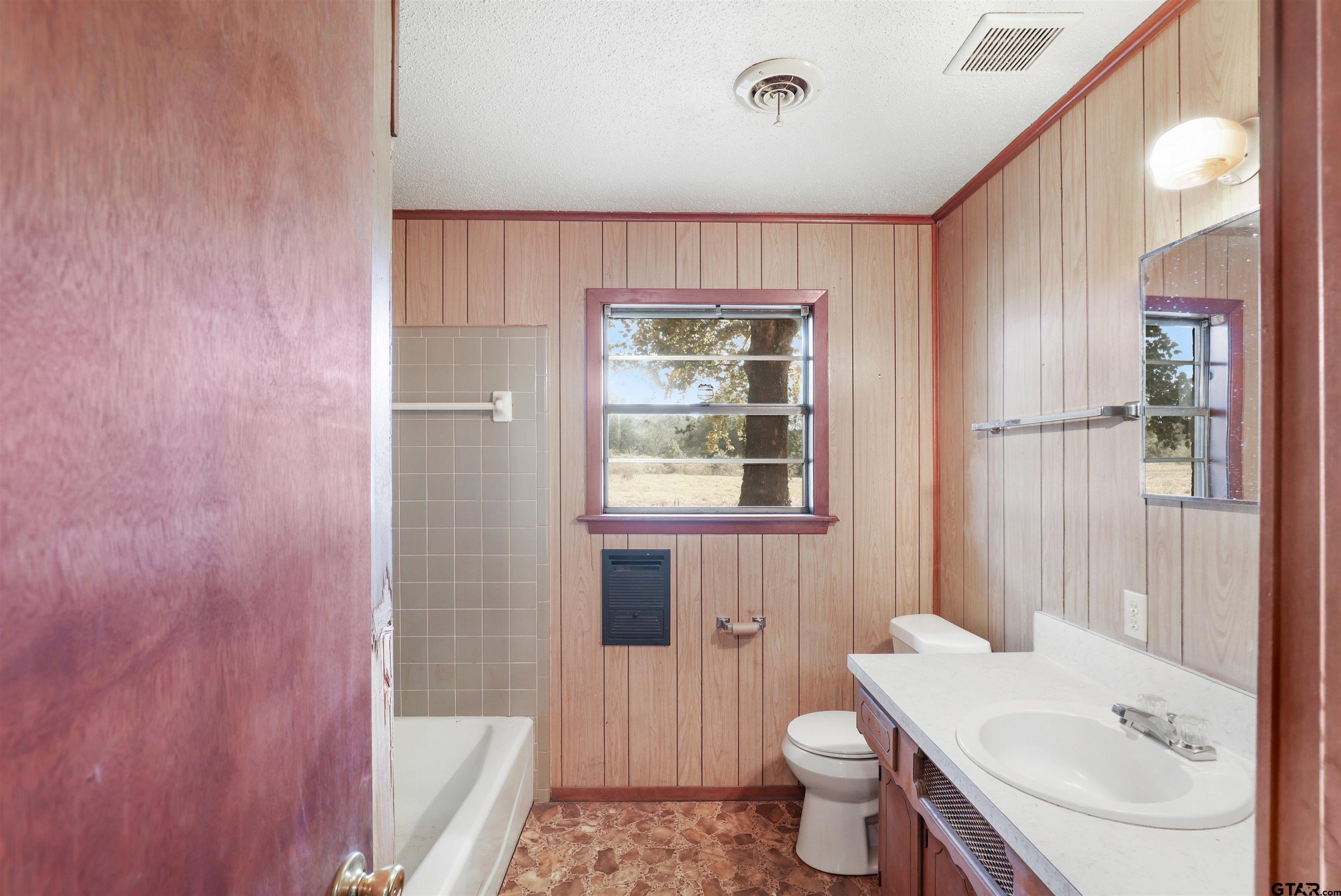 11768 Rose Trail Pittsburg, TX 75686 - Photo 4 of 20 a bathroom with a sink a toilet and shower curtain