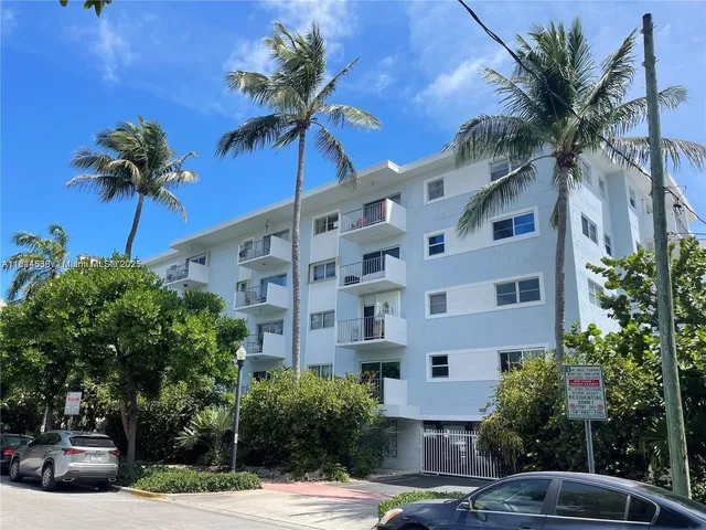 a front view of multiple houses with palm trees