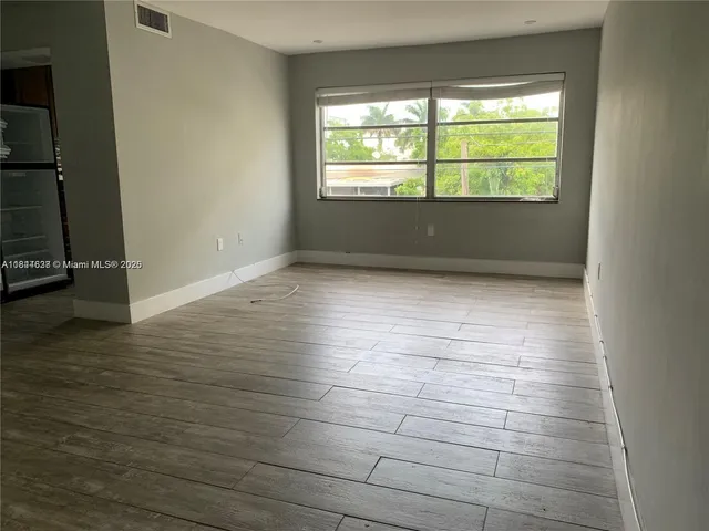 a view of wooden floor and windows in a room