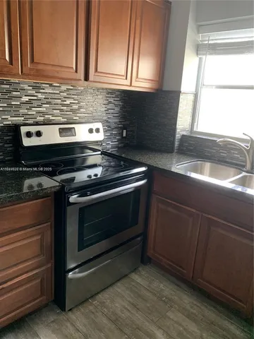 a kitchen with granite countertop a stove and a sink