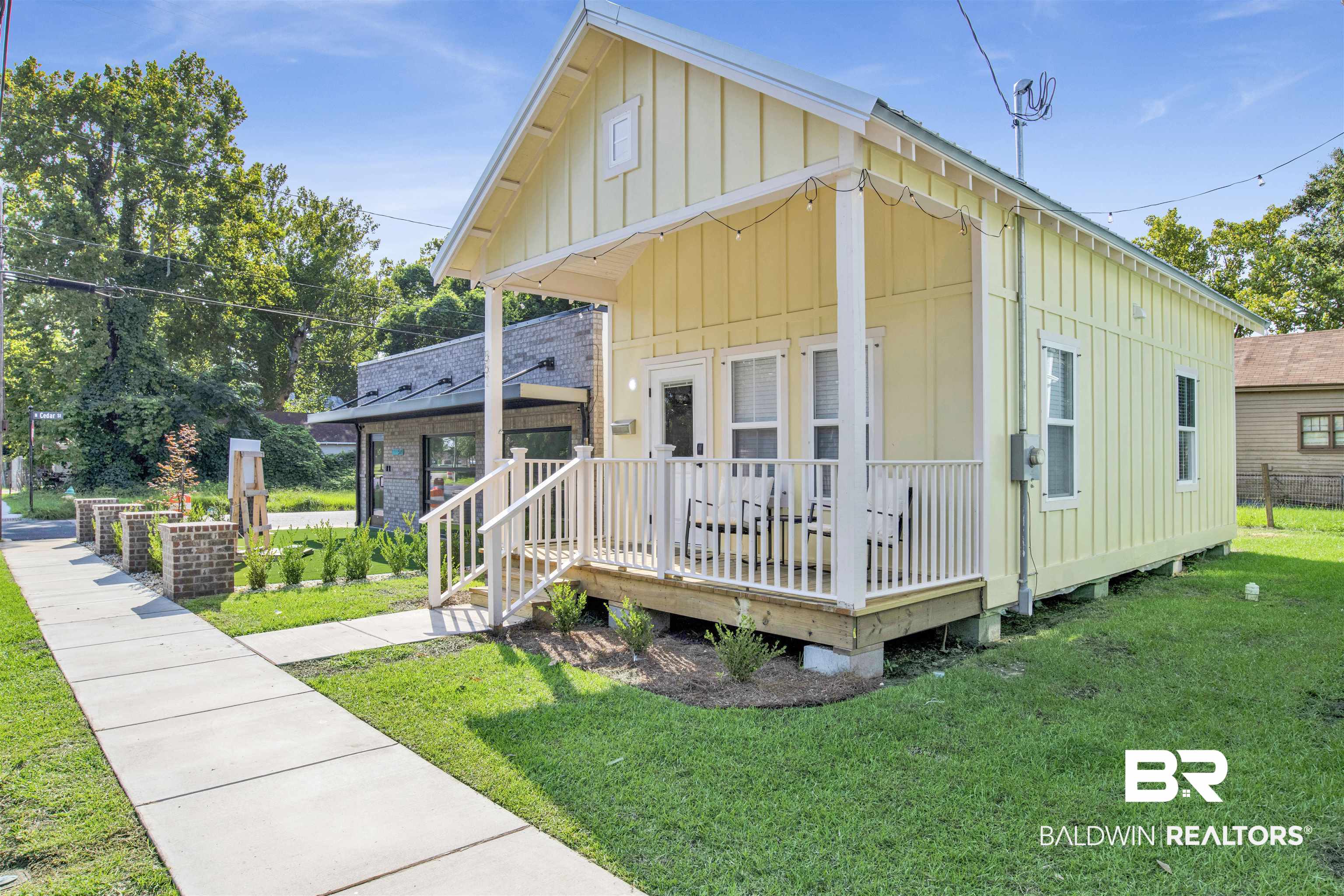 551 Congress Street Mobile, AL 36603 - Photo 1 of 19 View of front of property featuring board and batten siding, a front lawn, and a wooden deck