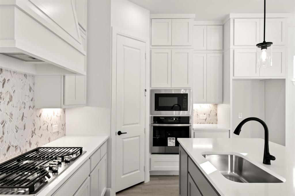 1105 Birdsong Trail Anna, TX 75409 - Photo 11 of 27 a kitchen with stainless steel appliances kitchen island a white stove top oven and sink