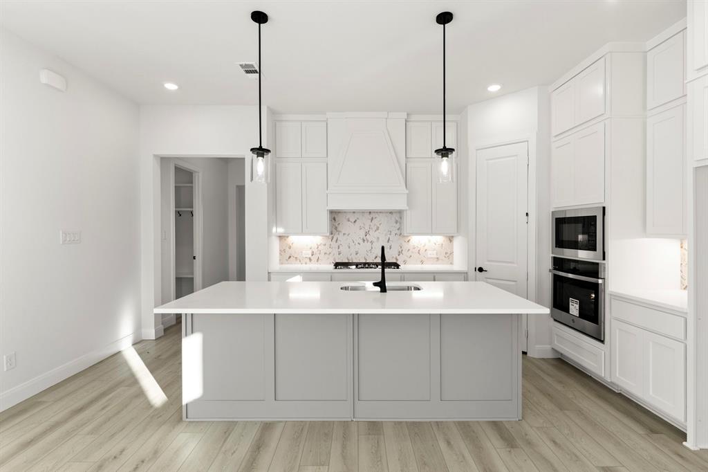 1105 Birdsong Trail Anna, TX 75409 - Photo 9 of 27 a kitchen with kitchen island a sink stainless steel appliances and cabinets