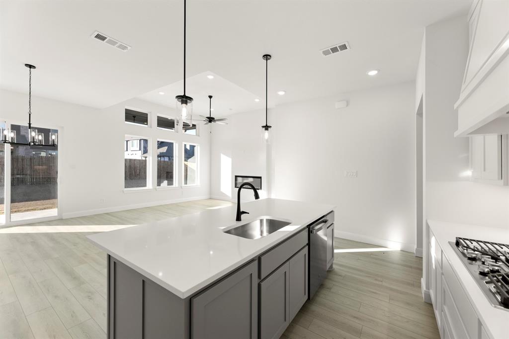 1105 Birdsong Trail Anna, TX 75409 - Photo 10 of 27 a kitchen with stainless steel appliances granite countertop a sink a center island and a window