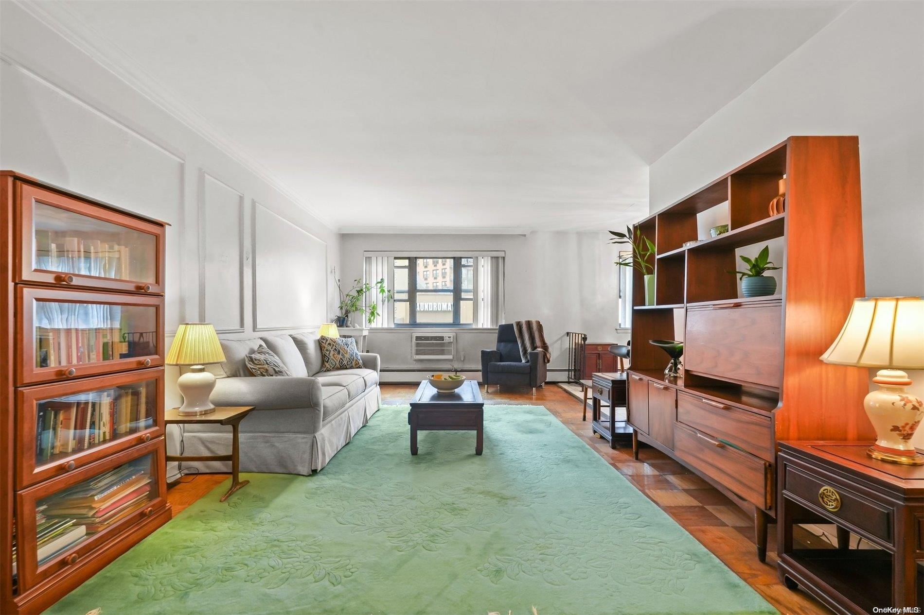 99-14 59th Avenue, Unit 1C Queens, NY 11368 - Photo 1 of 1 a living room with furniture and a flat screen tv