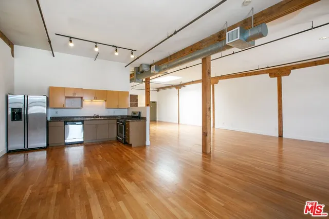 a kitchen with stainless steel appliances wooden floor and large windows