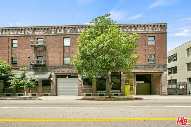 a front view of a building with a garden