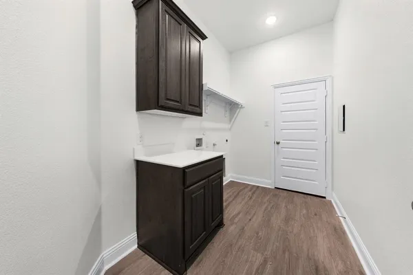 a kitchen with a wooden floor and cabinets