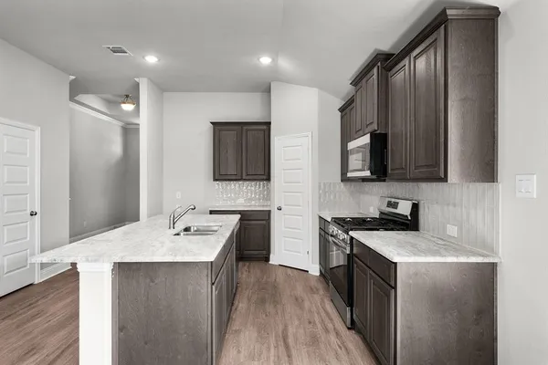 a kitchen with stainless steel appliances a sink stove and refrigerator