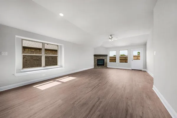 a view of empty room with a kitchen and wooden floor