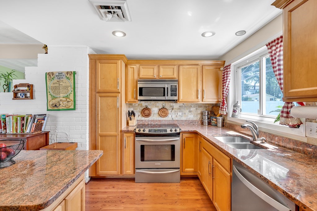 7 Leonard Road Framingham, MA 01701 - Photo 8 of 27 a kitchen with stainless steel appliances granite countertop a sink stove and refrigerator