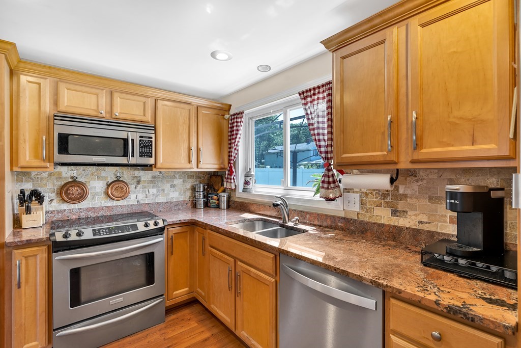 7 Leonard Road Framingham, MA 01701 - Photo 9 of 27 a kitchen with stainless steel appliances granite countertop a stove a sink and a microwave