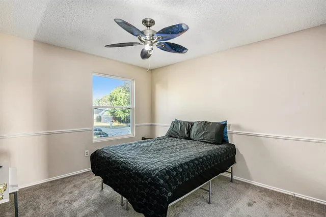 a bedroom with a bed and a ceiling fan