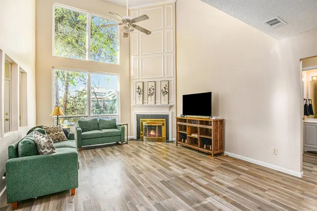 a living room with furniture a flat screen tv and a fireplace