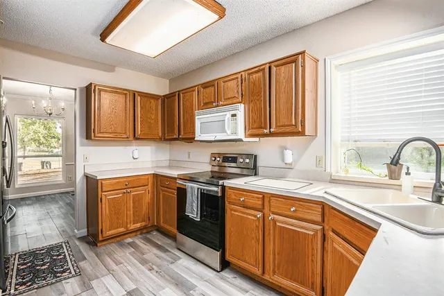 a kitchen with stainless steel appliances granite countertop a sink stove and cabinets