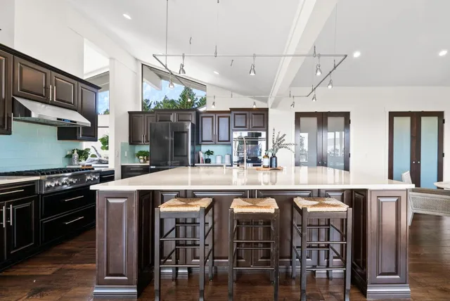 a kitchen with a refrigerator and a stove top oven