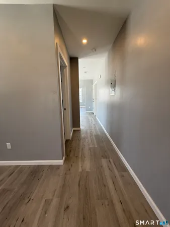 a view of a hallway with wooden floor