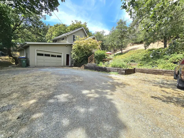 a view of house with outdoor space and trees in the background