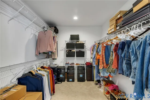 a view of walk in closet with clothes and shoes