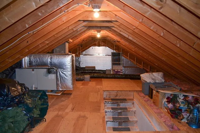 a living room with a couch and a potted plant on the wall