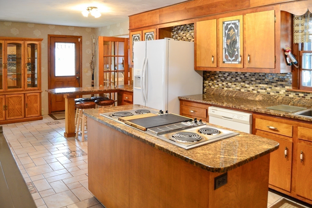 110 Mayflower Ridge Drive Wareham, MA 02571 - Photo 35 of 42 a kitchen with a stove a sink a refrigerator and wooden cabinets