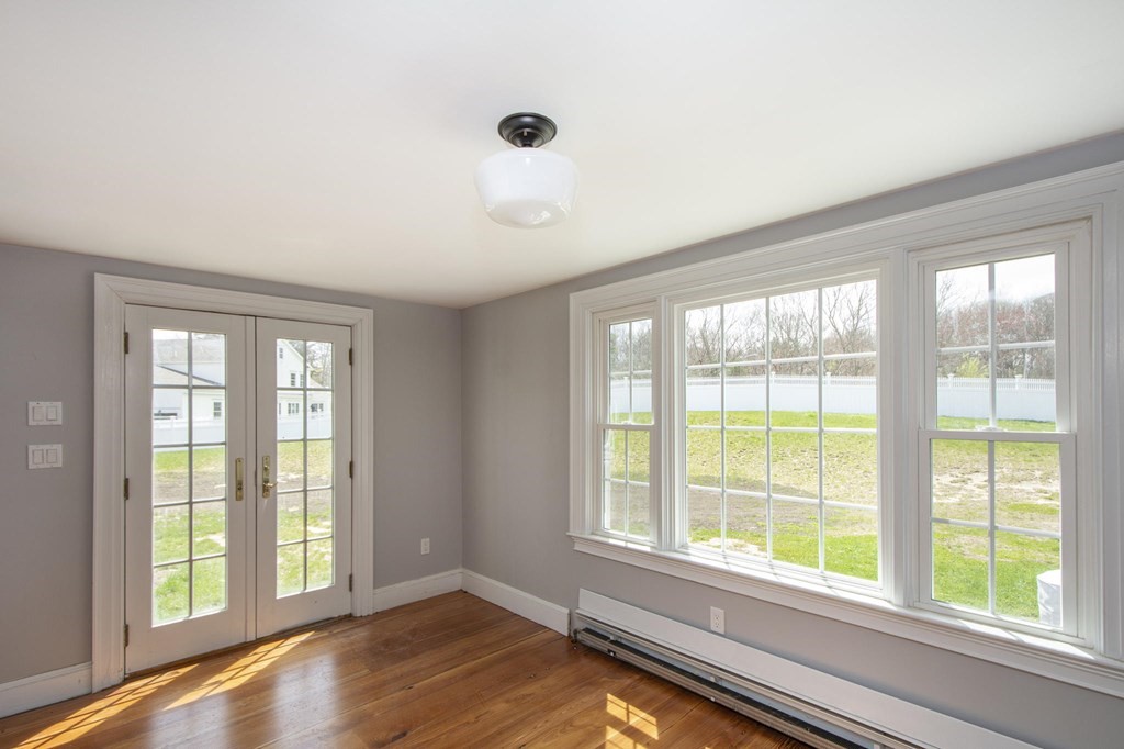 128 Washington Street, Unit F Hanover, MA 02339 - Photo 13 of 42 a view of an empty room with a window and wooden floor