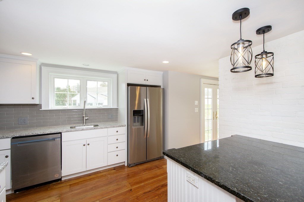 128 Washington Street, Unit F Hanover, MA 02339 - Photo 14 of 42 a kitchen with a sink dishwasher a stove and a refrigerator with wooden floor