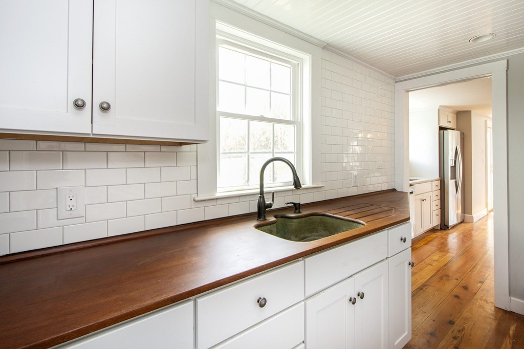128 Washington Street, Unit F Hanover, MA 02339 - Photo 16 of 42 a kitchen with granite countertop white cabinets and window