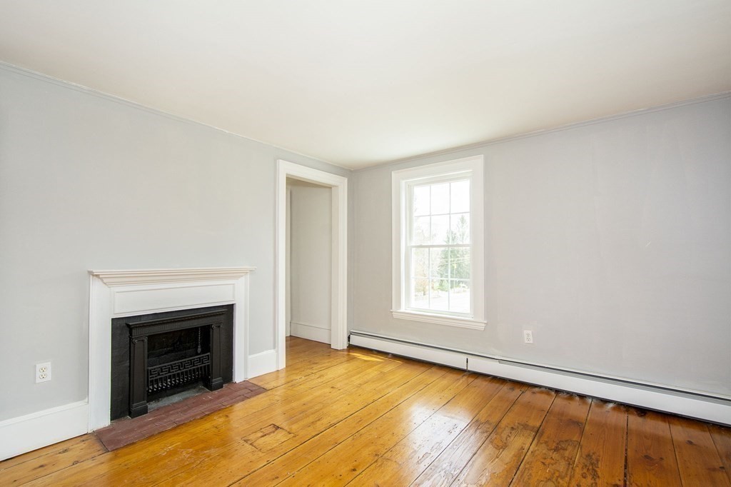 128 Washington Street, Unit F Hanover, MA 02339 - Photo 37 of 42 a view of an empty room with a fireplace and a window