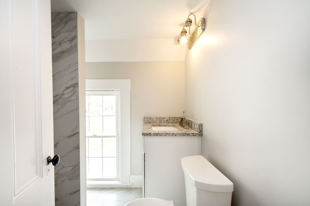 128 Washington Street, Unit F Hanover, MA 02339 - Photo 41 of 42 a bathroom with a toilet a sink and a window