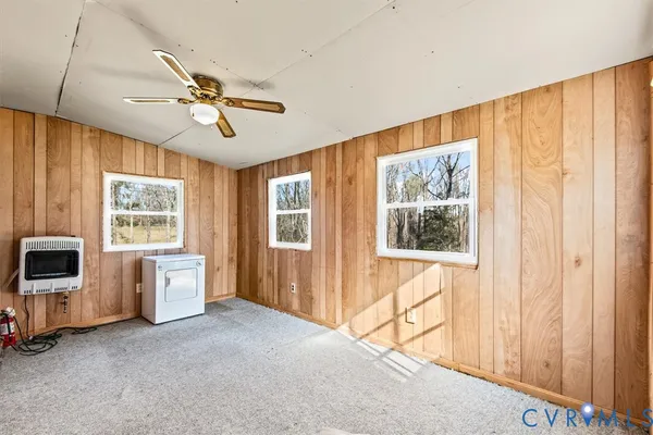 a view of a big room with windows and chandelier fan