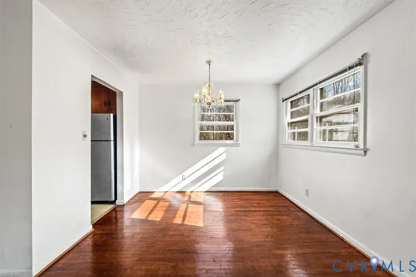 a very nice looking room with wooden floor windows and entryway