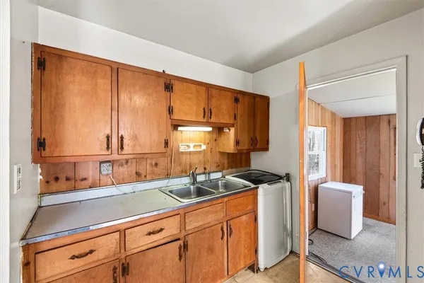 a kitchen with sink a window and cabinets