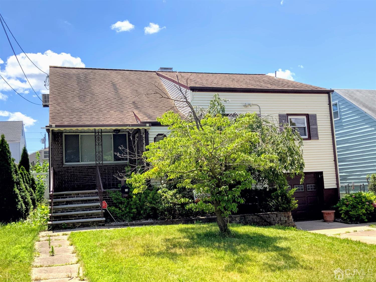 a front view of a house with a yard and a garden