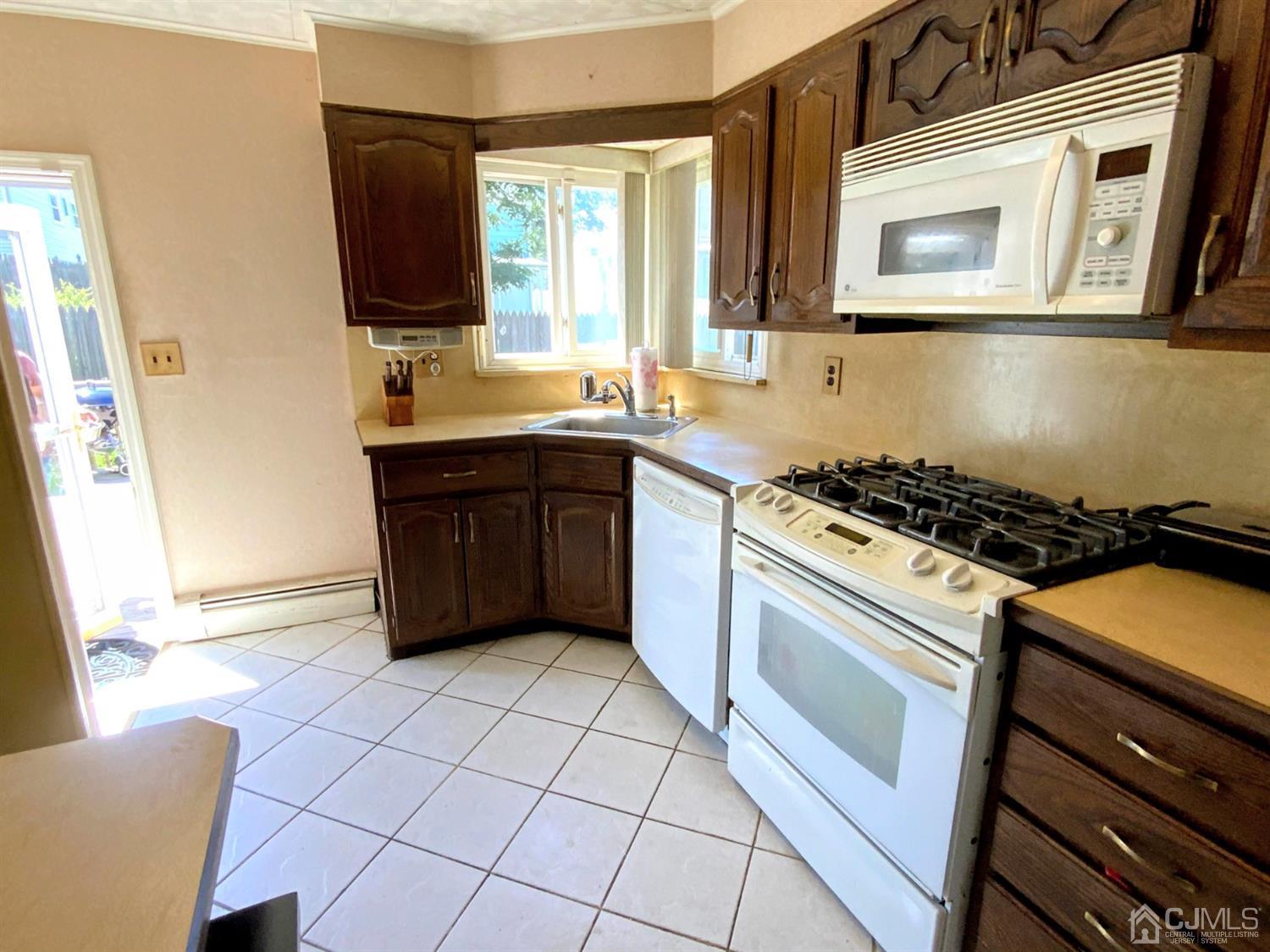 56 Farmingdale Road Fords, NJ 08863 - Photo 7 of 18 a kitchen with a stove a sink and a microwave