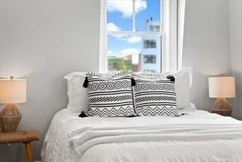 a large bed sitting in a bedroom next to a window