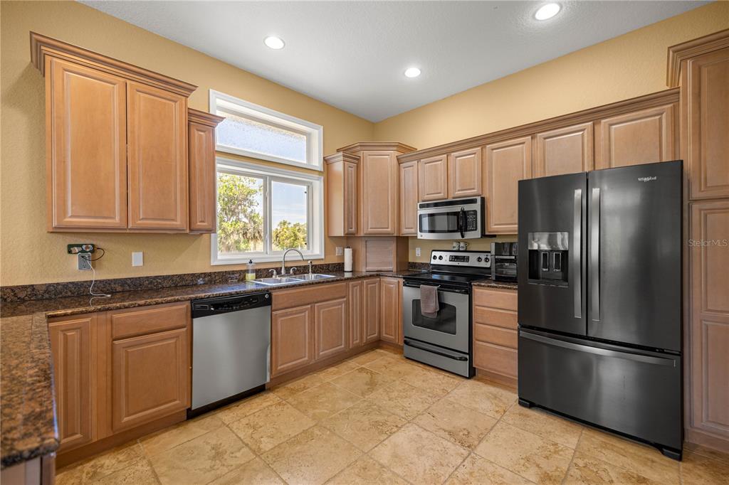3817 North Calusa Point Crystal River, FL 34428 - Photo 11 of 54 a kitchen with stainless steel appliances granite countertop a refrigerator stove top oven and sink