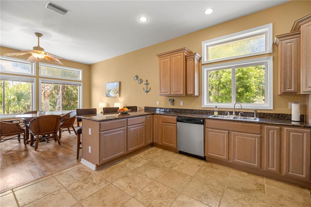 3817 North Calusa Point Crystal River, FL 34428 - Photo 12 of 54 a large kitchen with kitchen island granite countertop a stove a sink a dining table and chairs
