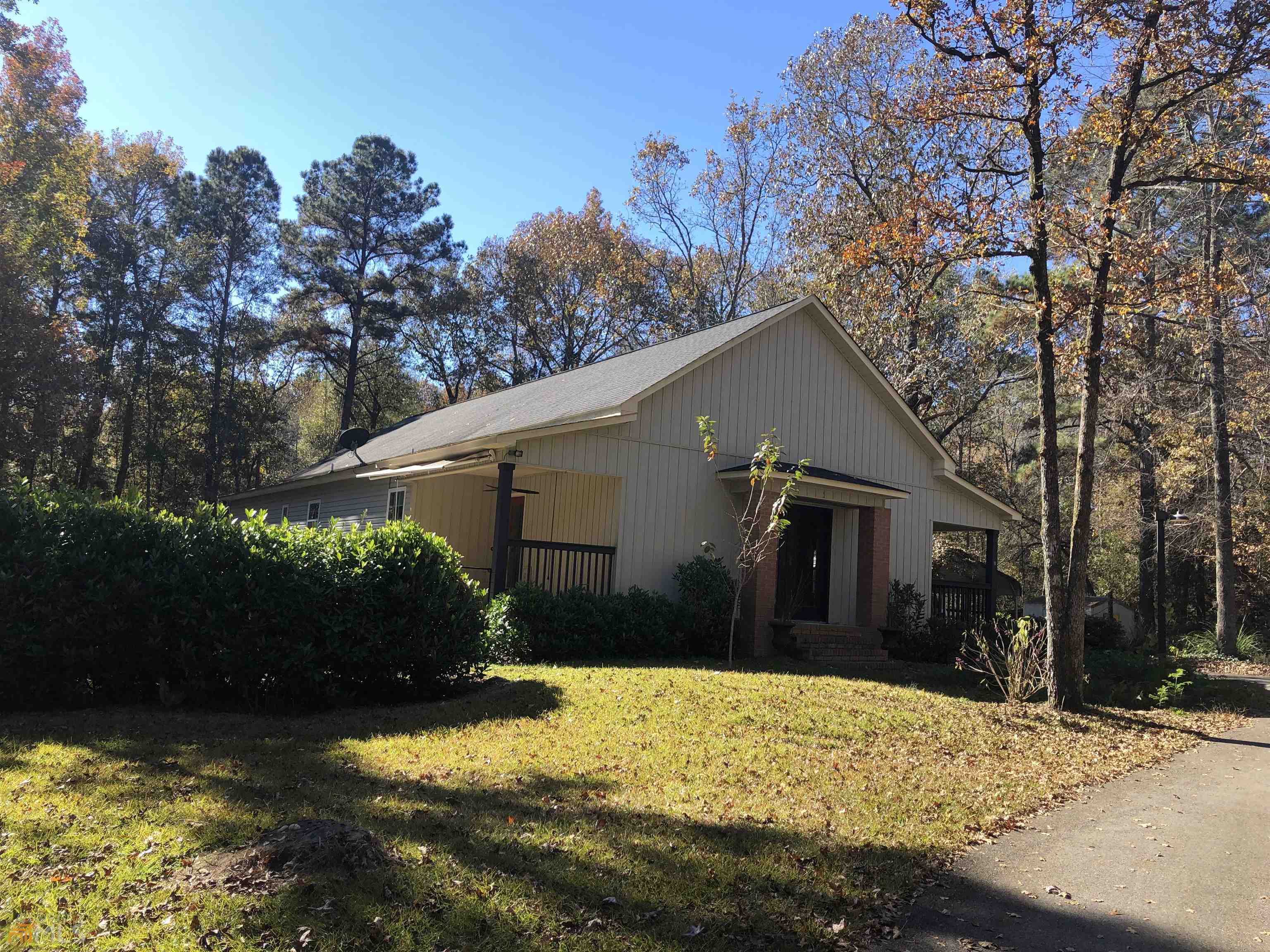 a front view of house with yard and trees in the background