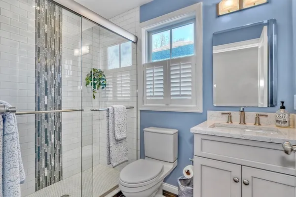 a bathroom with a sink a toilet and shower