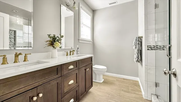 a bathroom with a sink a toilet and a mirror