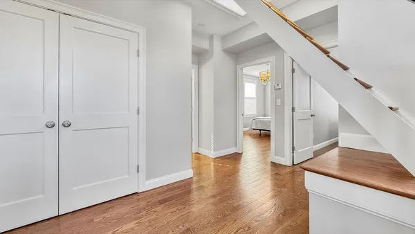 a view of a hallway with wooden floor and staircase