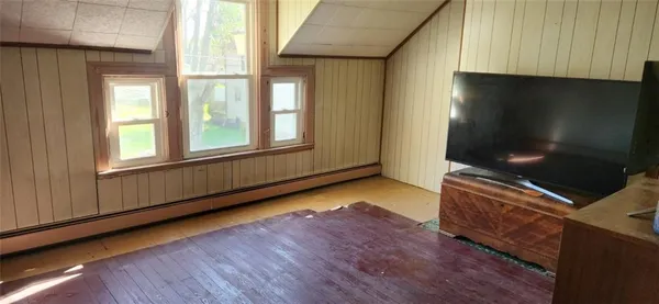 a living room with hard wood floors and a flat screen tv