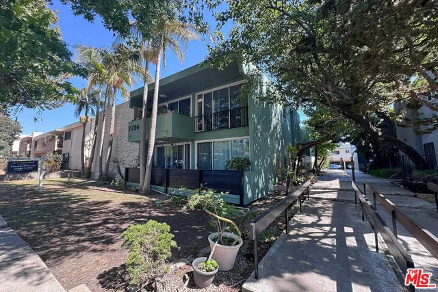 a view of a patio with table and chairs and a large tree