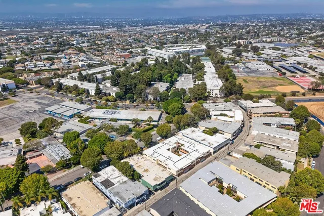 an aerial view of a residential houses with yard and mountain view in back