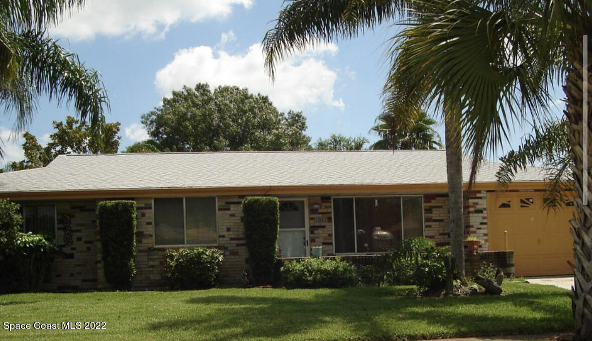 1067 Cromey Road Northeast Palm Bay, FL 32905 - Photo 1 of 1 a front view of house with a garden