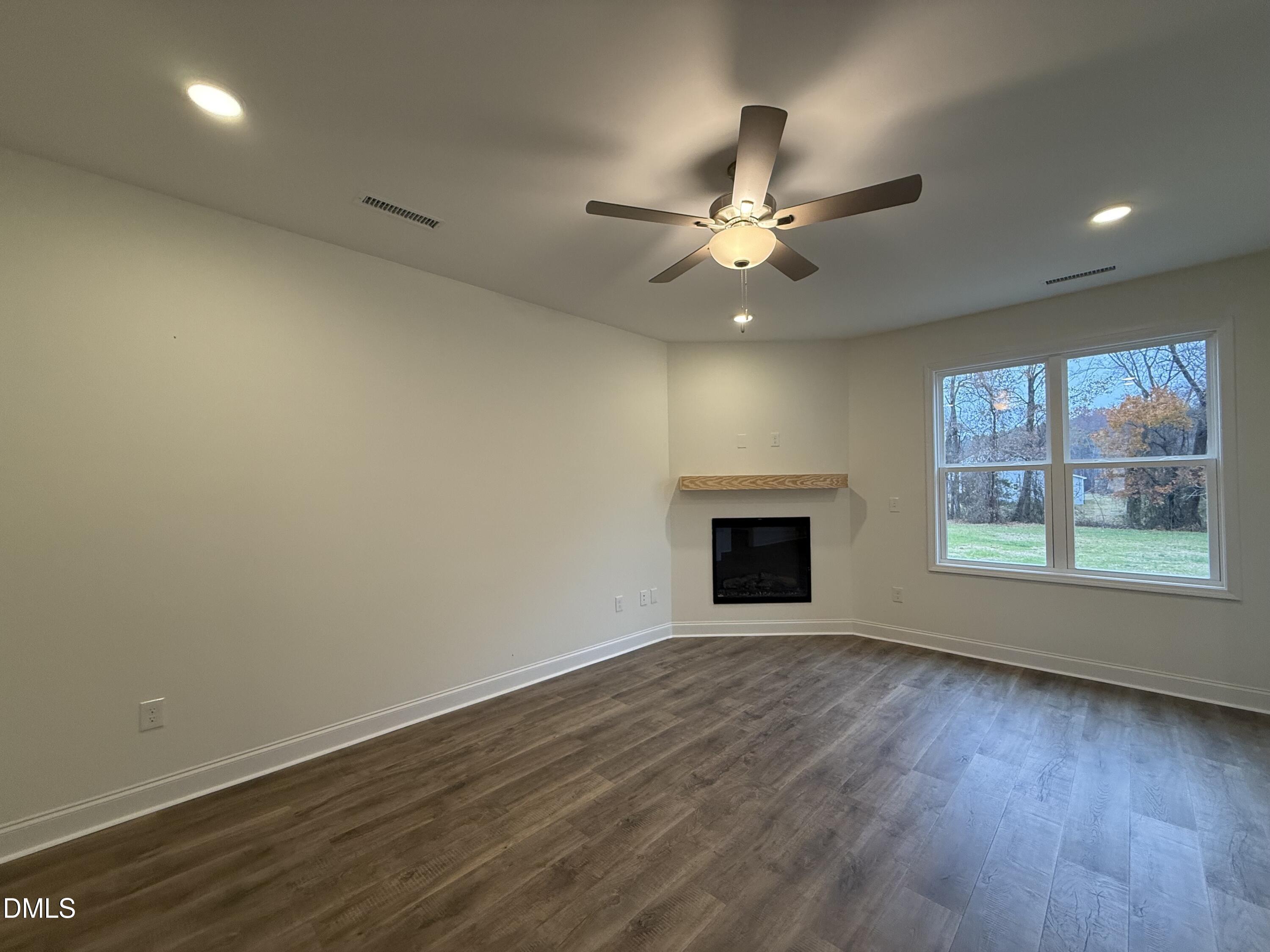 200 Longbow Drive Middlesex, NC 27557 - Photo 7 of 14 an empty room with wooden floor fan and windows