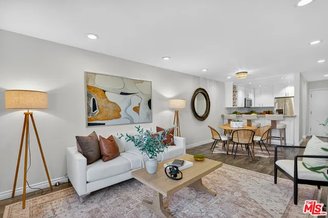 a living room with furniture a rug and white walls