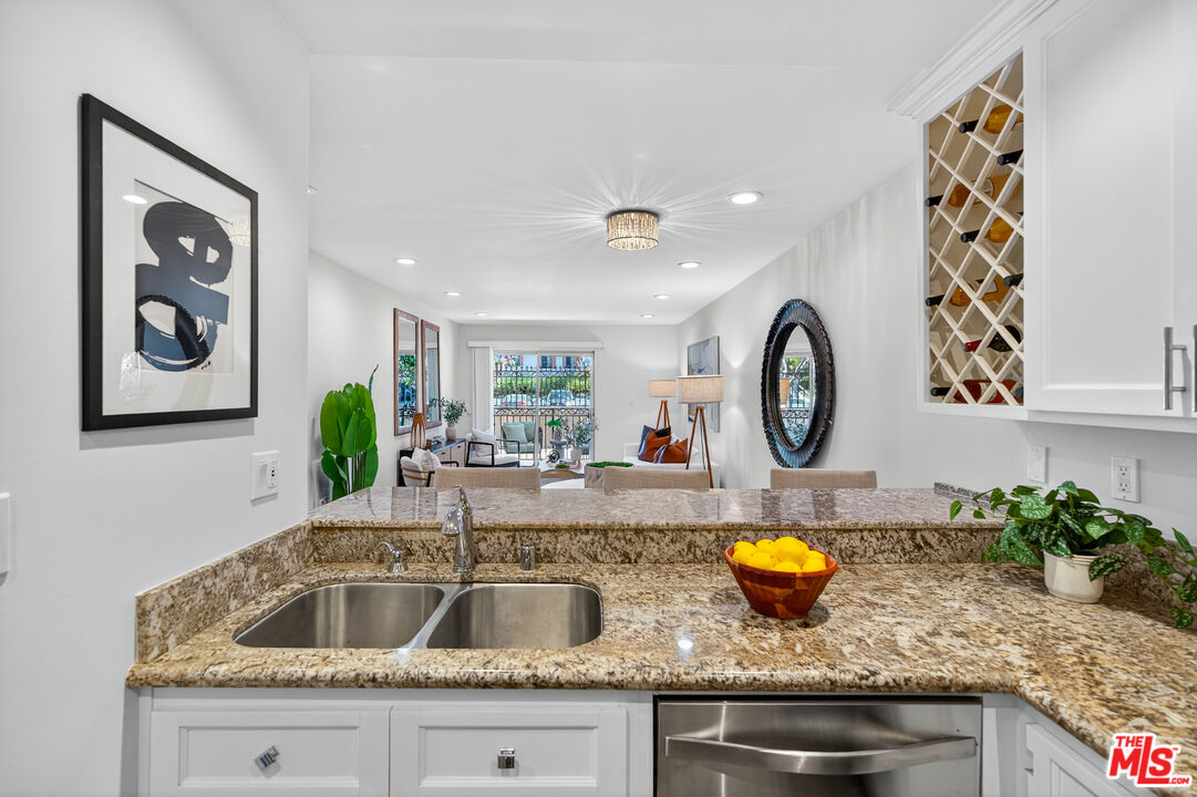 1125 Pico Boulevard, Unit 103 Santa Monica, CA 90405 - Photo 5 of 34 a kitchen with granite countertop a sink a stove and wooden floor